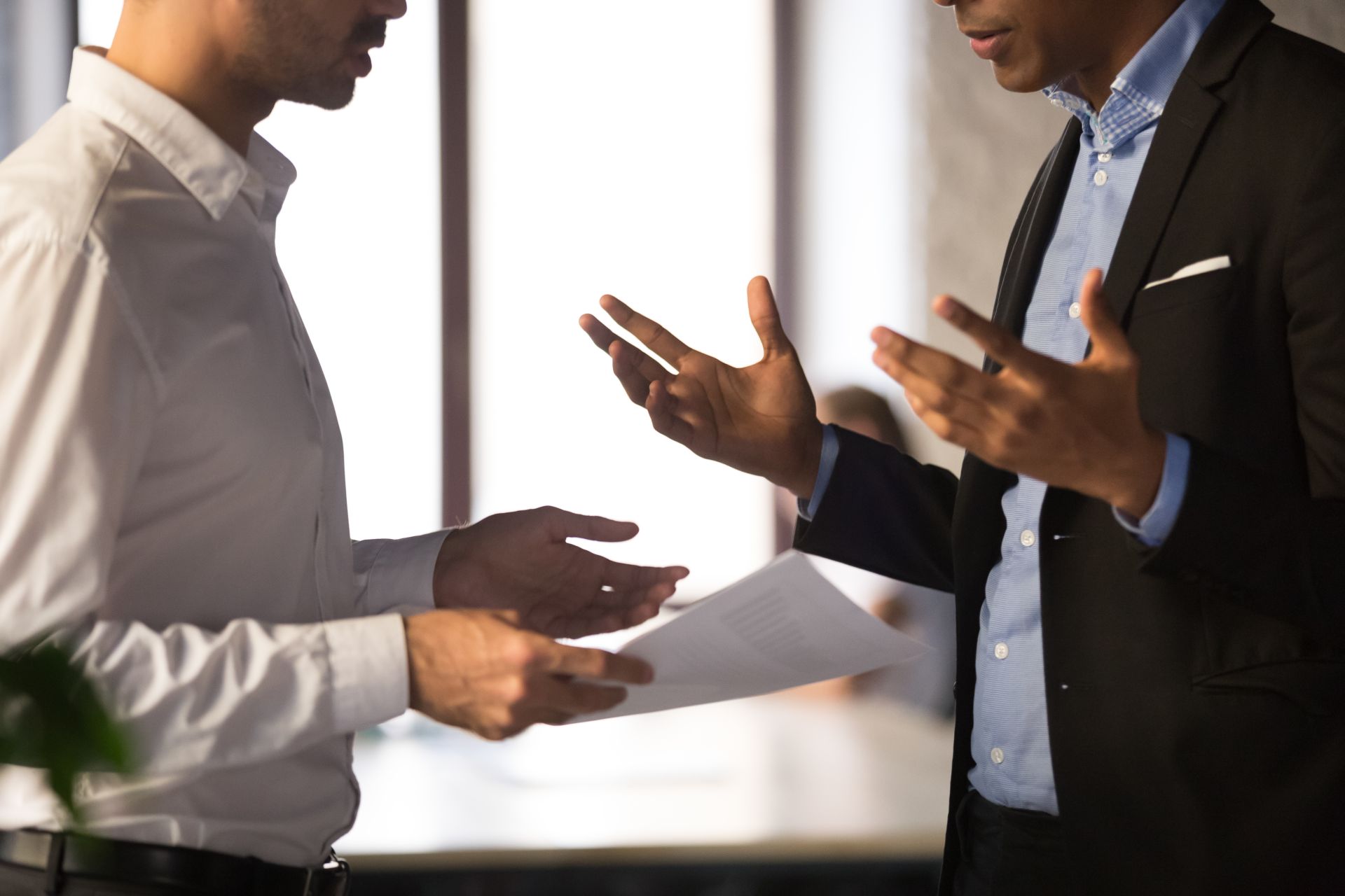 zwei Männer im Businessumfeld diskutieren und nutzen dabei stark die Gestik mit ihren Händen